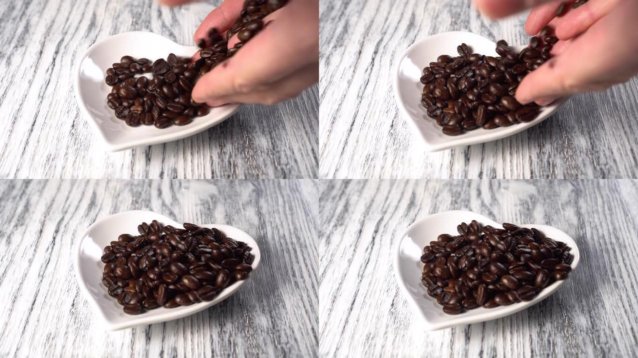 将烤咖啡豆从手中倒入白色茶碟中。心形