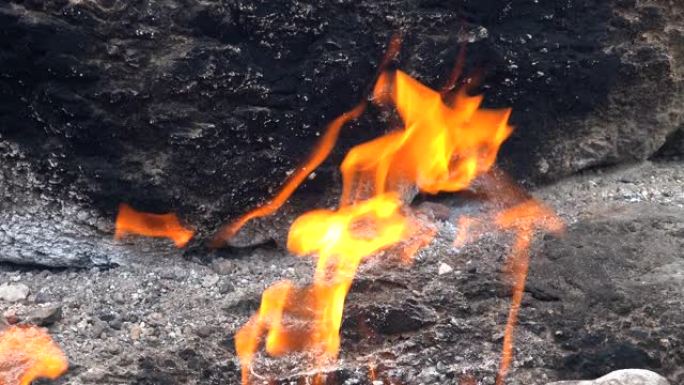 地下甲烷的火焰从岩石之间的裂缝中冒出来，并燃烧到地球
