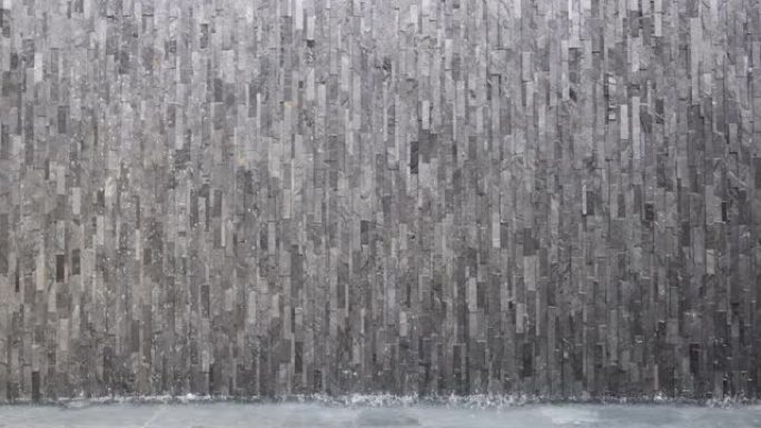 水从灰色混凝土墙上流下