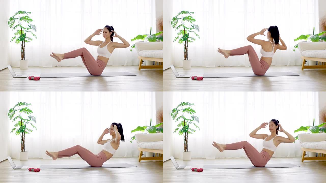 穿着运动服的年轻女子在家在瑜伽垫上进行运动训练