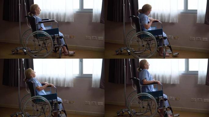 高级女病人独自坐在轮椅上，看着窗外试图站起来，但在医院病房失败了。孤独的老年女性在康复疗养院与风湿病