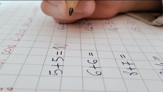 小学生在练习册上做数学作业的特写，家庭家庭