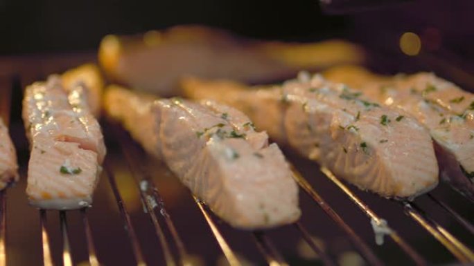 在烤架上的烤箱中煮熟时，腌料酱的特写外观被刷在鲑鱼片上。高温烹饪鲑鱼的概念，鲑鱼开始烧烤。
