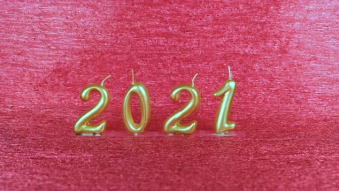 红色背景上的金色新年蜡烛2021。现代概念