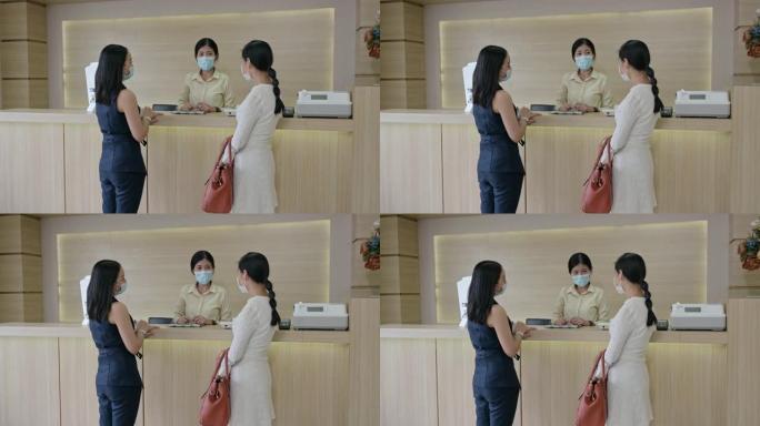 生病的亚洲妇女，姐姐戴着口罩，接待处联系接待员