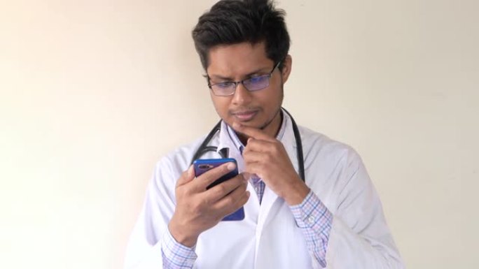 穿着白大褂的年轻亚洲医生使用智能手机。