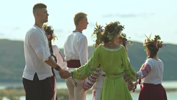 美丽而年轻的妇女头上戴着花圈，穿着斯拉夫民族的民间服装，传统和习俗跳舞。带有装饰品的民间服装，伊万·
