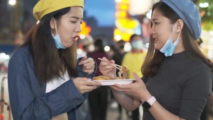 旅行者亚洲博客女人在泰国曼谷旅行，女人在曼谷市市场吃传统的亚洲街头食品。美女吃泰国街头食品的特写。