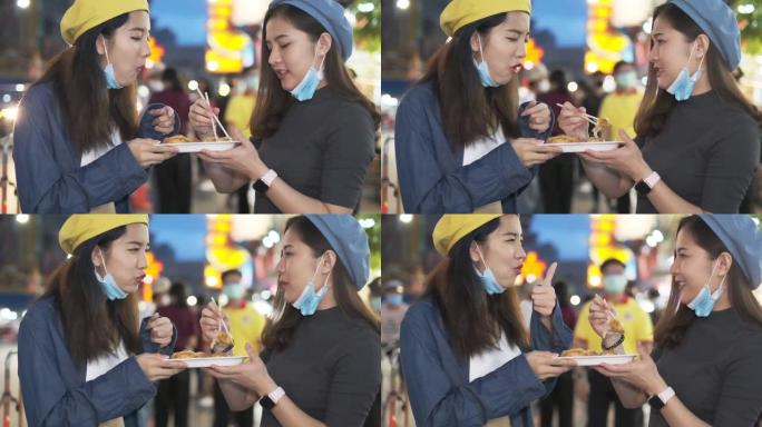 旅行者亚洲博客女人在泰国曼谷旅行，女人在曼谷市市场吃传统的亚洲街头食品。美女吃泰国街头食品的特写。
