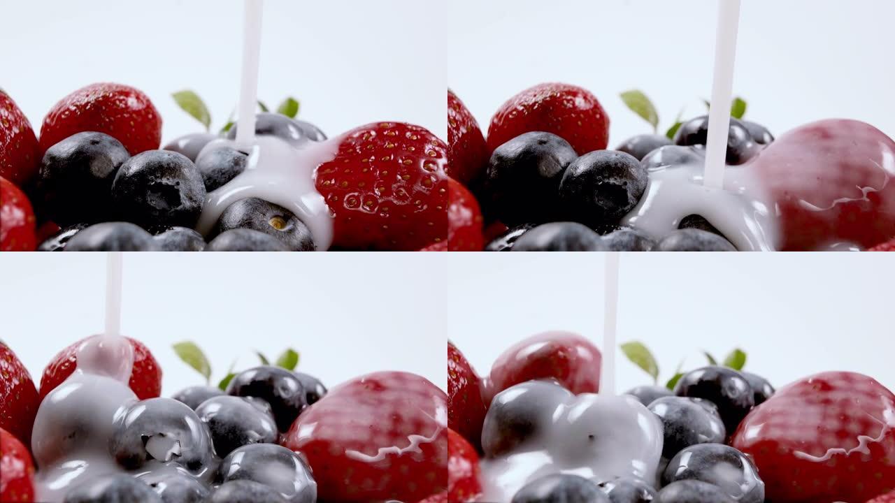 将酸奶或牛奶倒在有机新鲜蓝莓和草莓上。鲜奶油浆果。有机素食概念。特写，4k分辨率。