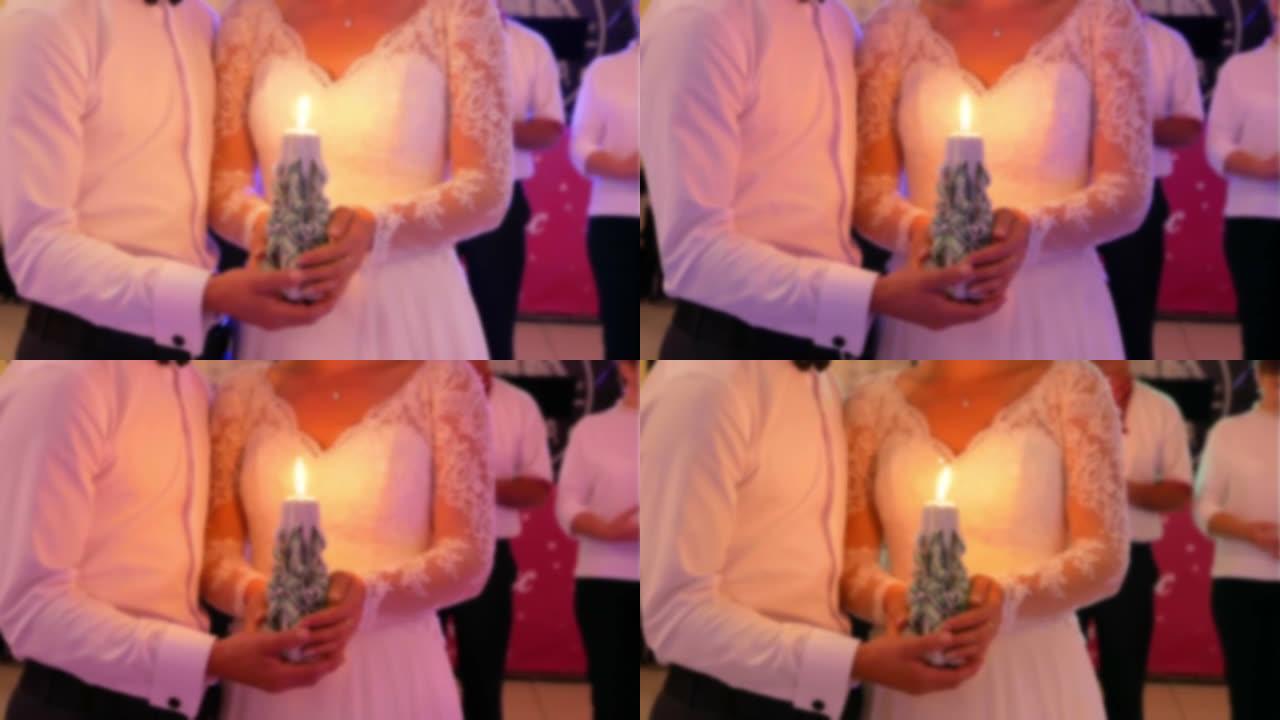 模糊的慢动作视频。美丽时尚的年轻婚礼情侣要结婚了，手里拿着蜡烛。新娘和新郎的婚礼。