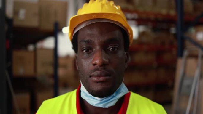快乐非洲工人男子在送货箱仓库内，戴着冠状病毒爆发的防护口罩