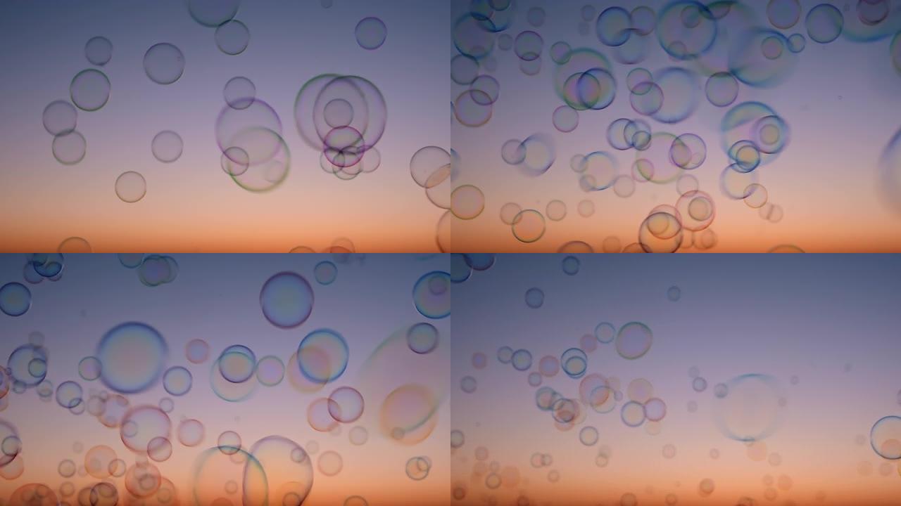 日落时天空上的肥皂泡夏天慢动作。明亮的背景五彩气泡在天空中平滑飞行。童年，自由。梦。放松。幸福