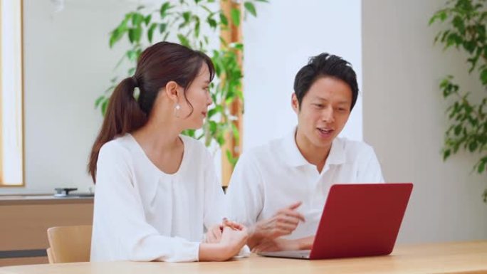 亚洲夫妇在家里使用笔记本电脑
