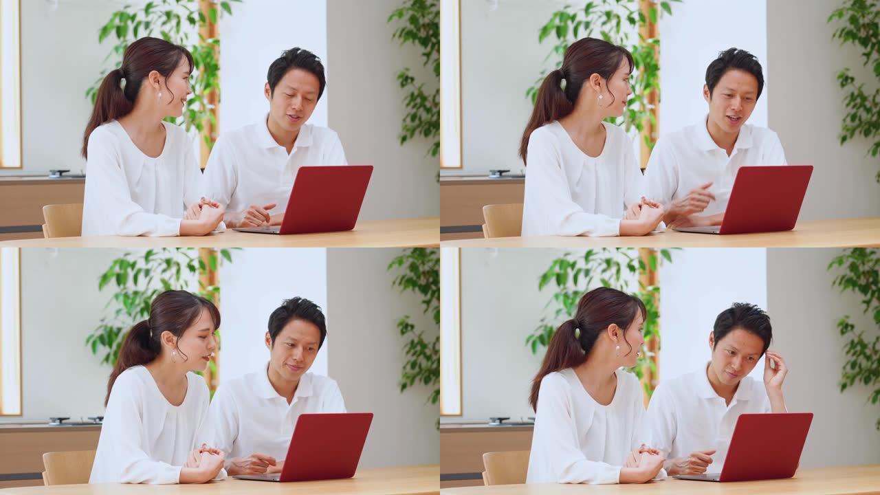 亚洲夫妇在家里使用笔记本电脑