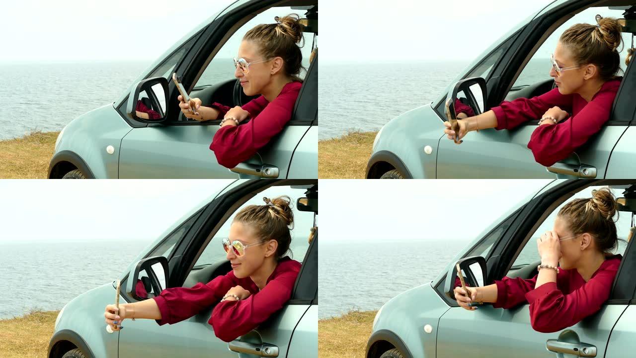 年轻女子在海岸上的一辆汽车上的智能手机上自拍