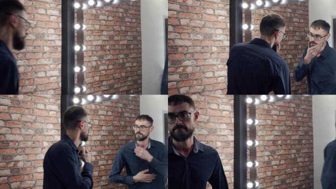 大胡子男人离开公寓前看着镜子。留着胡须和眼镜的英俊男人看着镜子离开。