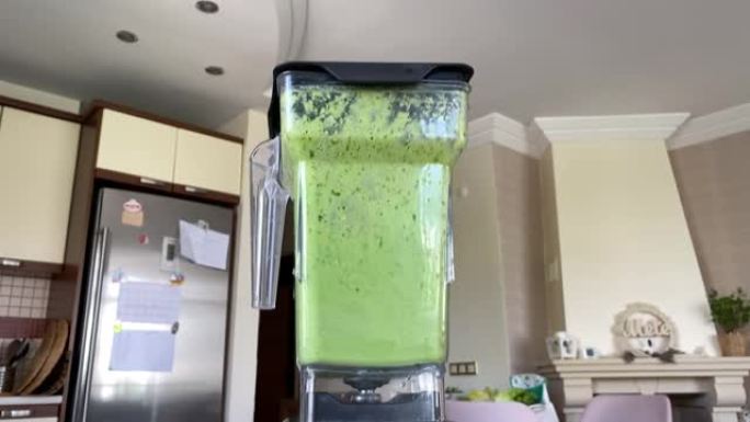 搅拌器罐子里旋转的绿色冰沙
