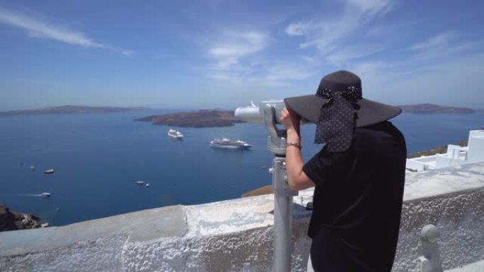 欧洲度假旅游游客在圣托里尼市街上漫步，透过塔观众投币机、双筒望远镜观看地中海游轮