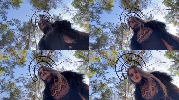 女巫形象的女人站在森林中树木和天空的背景下。