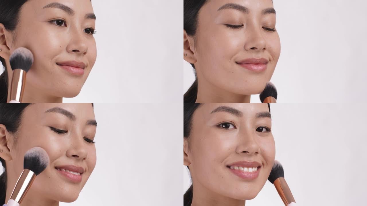 年轻的亚洲女士用化妆刷在脸上涂上腮红。化妆品概念，特写，白色工作室背景