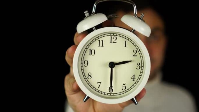 2:30点。人类手持闹钟，显示二点三十分的铃声。