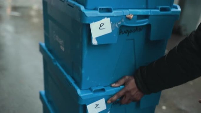 一名非裔美国男性的手用货物推蓝色盒子。送餐