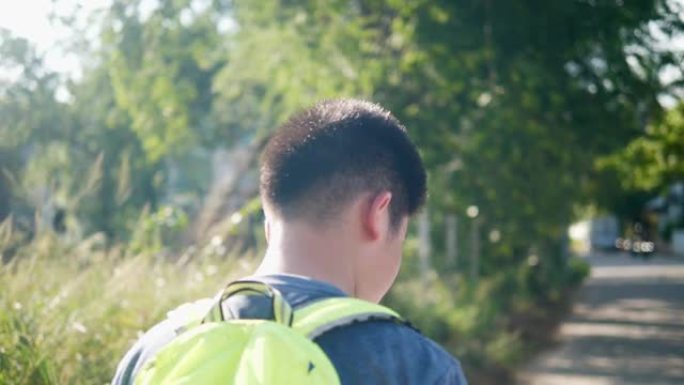 快乐的亚洲背包客男孩在家庭旅行中带着自然阳光行走，生活方式理念。