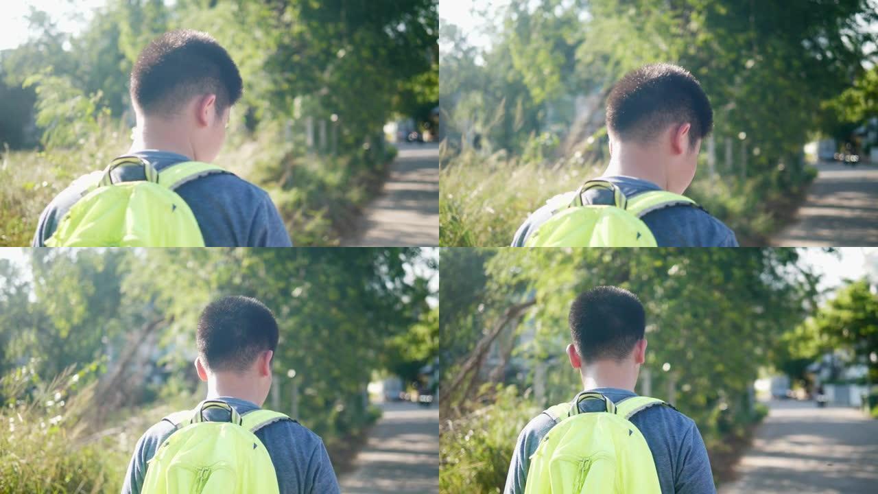 快乐的亚洲背包客男孩在家庭旅行中带着自然阳光行走，生活方式理念。