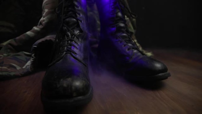 战争概念。深色雾气背景下的旧军鞋。国家间冲突、军事攻击的创造性概念。选择性聚焦