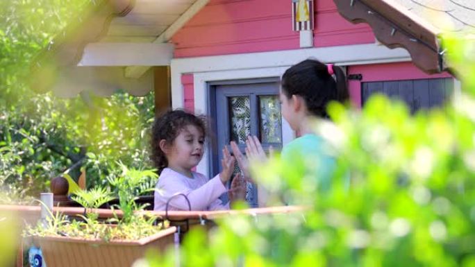 两个姐妹在粉红色的树屋里玩耍，孩子们在树屋里玩耍