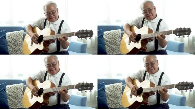 亚洲资深男子坐在沙发上弹原声吉他。快乐微笑的老人唱歌和享受吉他。在家享受退休生活。
