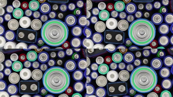 不同类型和等级的废旧碱性电池特写。许多废旧电池会旋转。电池对地球性质和处置的有害影响