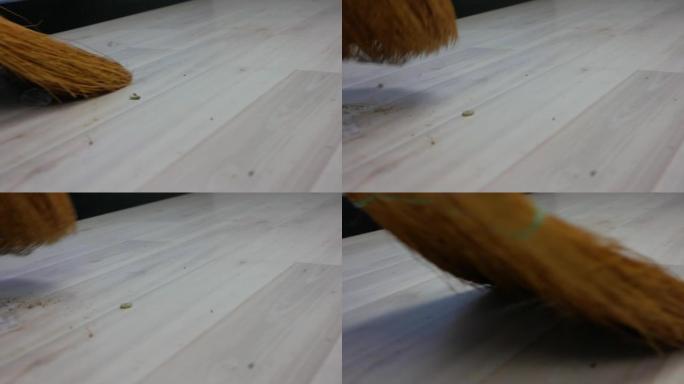 扫帚用白色强化地板扫除房屋中的灰尘。大量污垢和灰尘