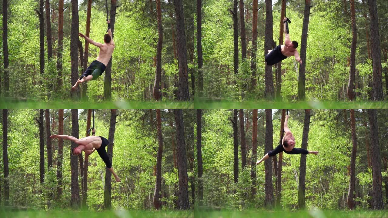马戏团艺术家在绿色公园用空中吊带做健美操。