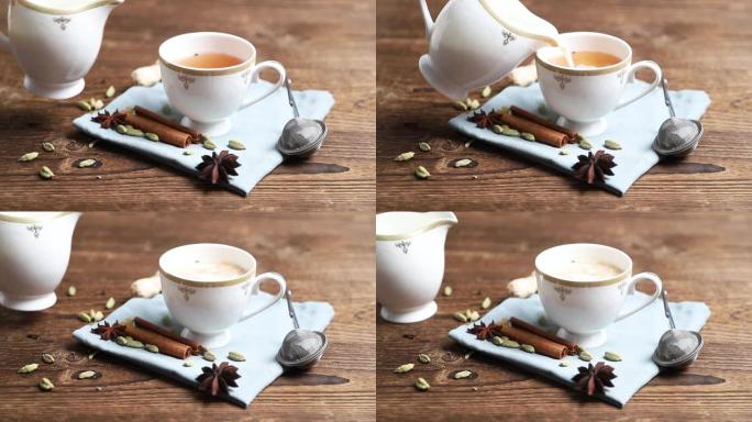 全高清镜头，制作茶弥撒。牛奶是从白牛奶壶里倒入一个装有红茶的瓷杯，放在木桌上。
