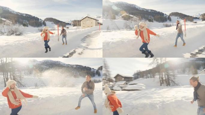 嬉戏的年轻夫妇在阿尔卑斯山的冬天互相扔雪球
