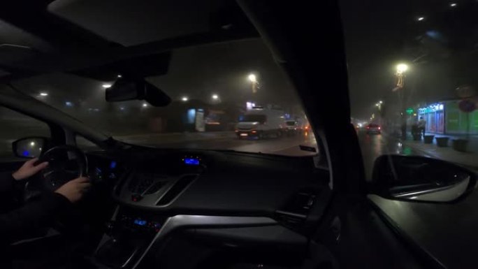 雨雾中夜间驾车穿越城市-视频4k镜头汽车驶过城市，从乘客的角度看gopro摄像机