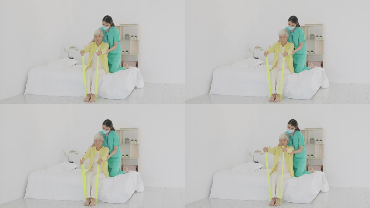 手臂关节炎的亚洲高级女性在家里的卧室接受专业护士或家庭健康助手的关节炎物理疗法调色乐队康复。