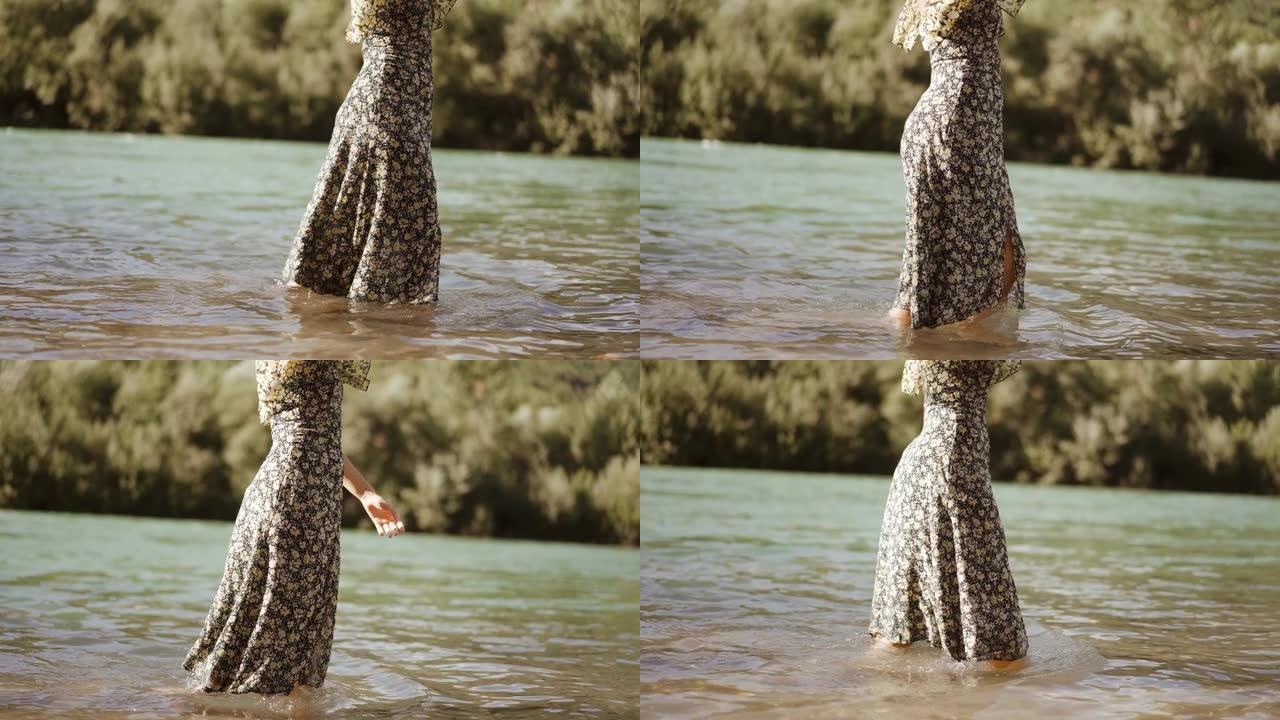 美丽的金发女孩走在河边，在河边阳光明媚的日子里，用相机放松