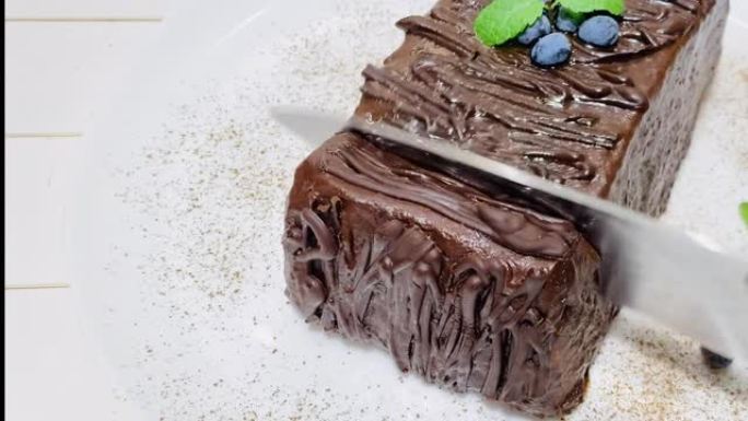 用刀切开巧克力蛋糕。