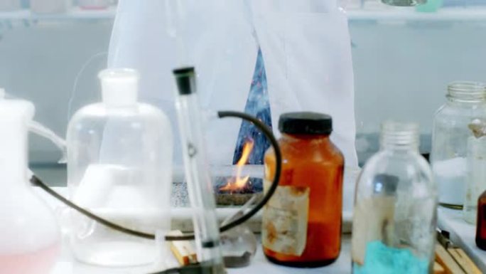 在化学实验室中，科学家试图制作烟花，在镜头上的火特写镜头上添加一些粉末