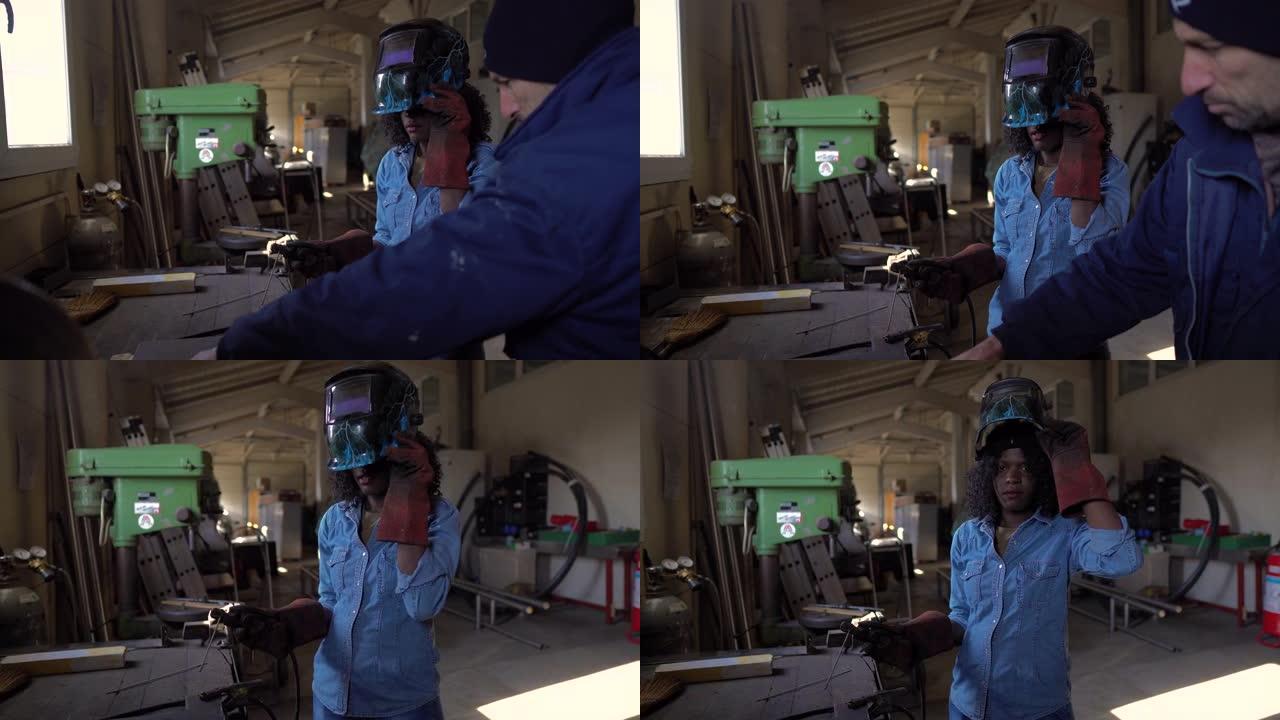 在工厂工作的年轻女焊工穿着防护安全装备