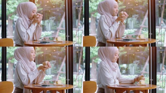 年轻的亚洲穆斯林妇女在咖啡店里享受放松的时光