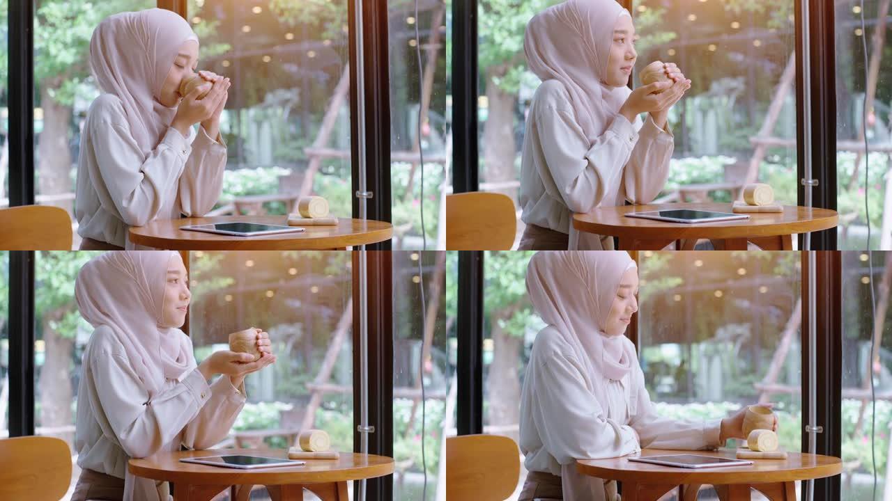 年轻的亚洲穆斯林妇女在咖啡店里享受放松的时光