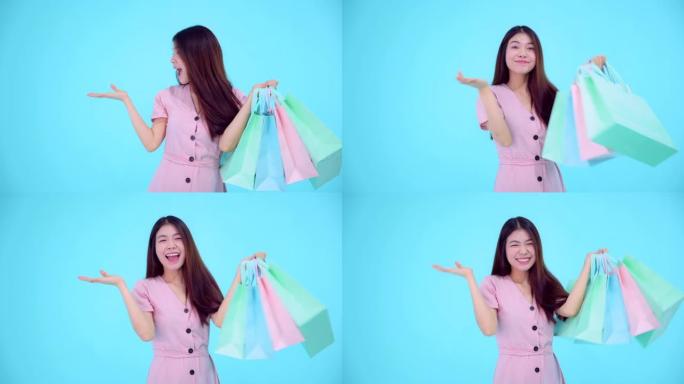 年轻亚洲女子手里拿着购物袋，快乐情感购物理念