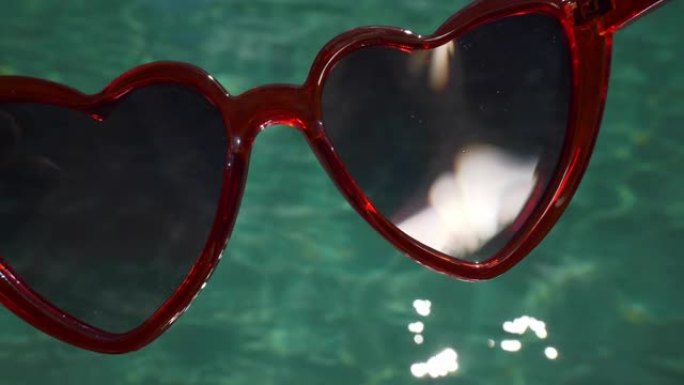 阳光明媚的一天巴厘岛豪华酒店游泳池红心太阳镜慢镜头4k印尼
