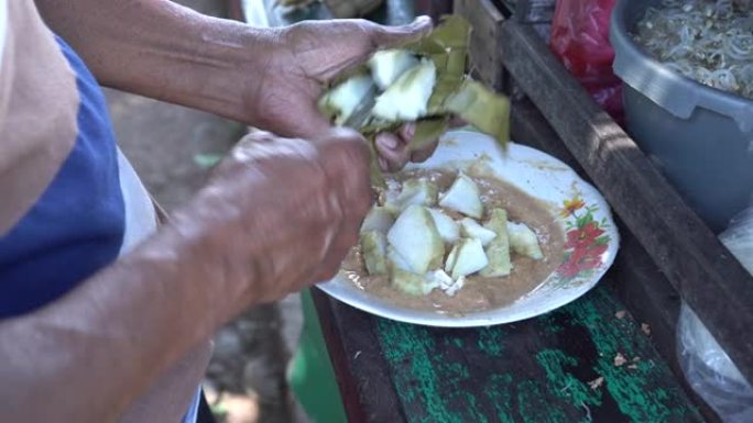 传统食品供应商正在制作印尼地道食品，称为ketoprak
