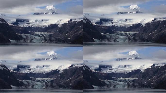 约翰·霍普金斯冰川及其周围的白雪皑皑的山脉和云。阿拉斯加的冰川湾景观。