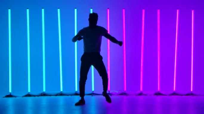 舞者以慢动作表演萨尔萨舞节目中的舞蹈元素。在演播室里的彩色霓虹灯背景下，男人们的剪影